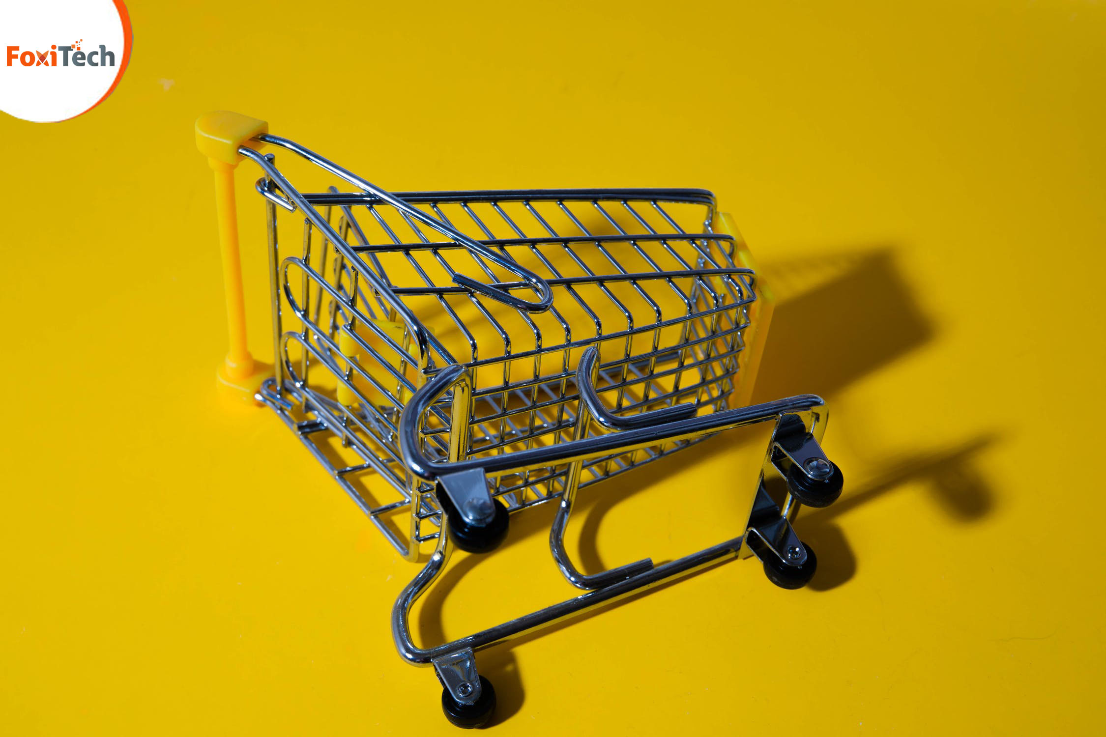 A toy shopping cart on its side on a yellow surface